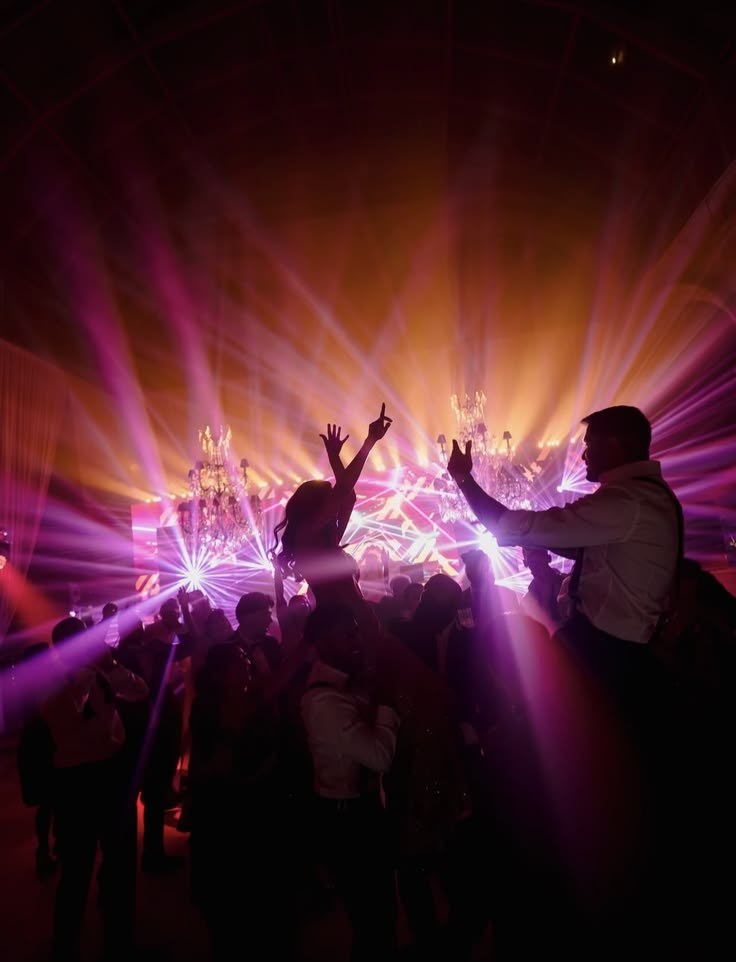 Guests on shoulders under laser beams at a reception