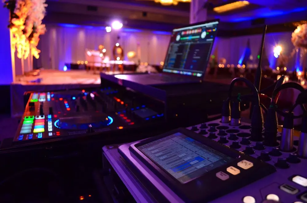 Sher DJ booth lit in purple at a reception